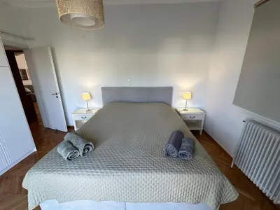 a bedroom with a large bed with two night stands at AthensView Skyline High-rise with Acropolis view -TWO BEDROOM FLAT in Athens