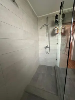 a shower with a glass door in a bathroom at AthensView Skyline High-rise with Acropolis view -TWO BEDROOM FLAT in Athens