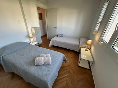 a room with two beds and a window at AthensView Skyline High-rise with Acropolis view -TWO BEDROOM FLAT in Athens