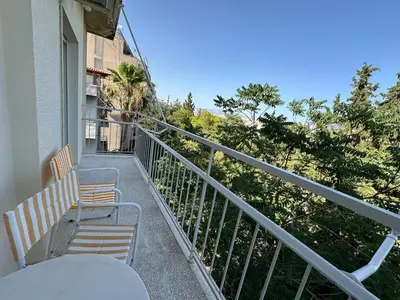 a balcony with chairs and a table on a building at AthensView Skyline High-rise with Acropolis view -TWO BEDROOM FLAT in Athens