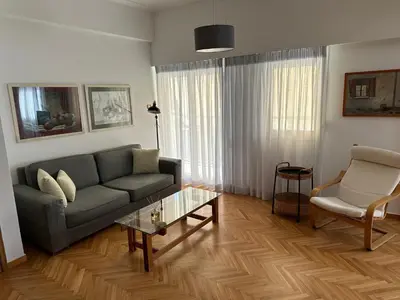 a living room with a couch and a table at AthensView Skyline High-rise with Acropolis view -TWO BEDROOM FLAT in Athens