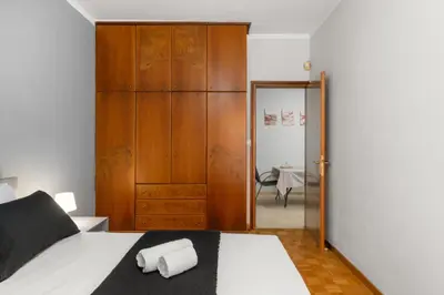 a bedroom with a bed and a wooden closet at Adigonis Apartment next to the metro station in Athens