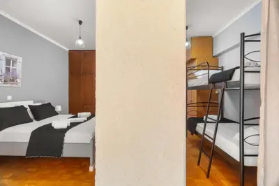 a bedroom with a bed and a bunk bed at Adigonis Apartment next to the metro station in Athens