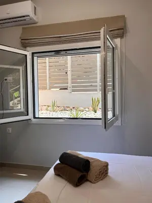 a window in a bedroom with a towel on a bed at Athens Urban Retreat Apartment - City Center - Fiber Wi-Fi in Athens