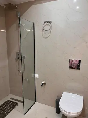 a bathroom with a toilet and a glass shower at Athens Urban Retreat Apartment - City Center - Fiber Wi-Fi in Athens