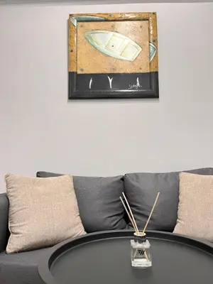 a couch with a table and a picture on the wall at Athens Urban Retreat Apartment - City Center - Fiber Wi-Fi in Athens