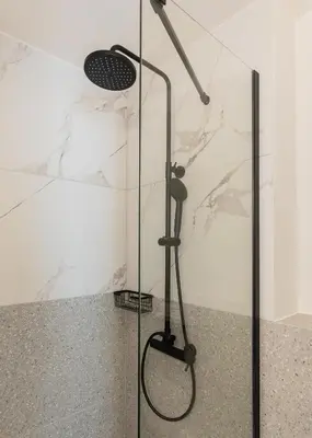 a shower with a glass door in a bathroom at KLEO by Zoia Living in Athens