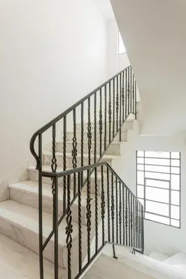 a staircase with black railings and white walls at KLEO by Zoia Living in Athens