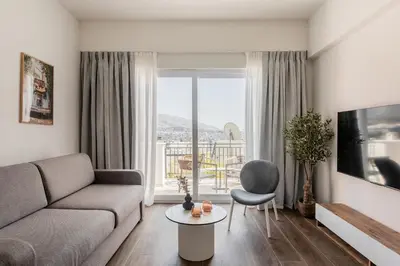 a living room with a couch and a large window at KLEO by Zoia Living in Athens
