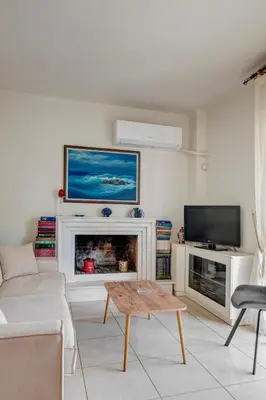 a living room with a fireplace and a tv at Aura in Piraeus