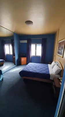 a bedroom with a large bed with blue walls at Athens Lydia Hotel in Athens