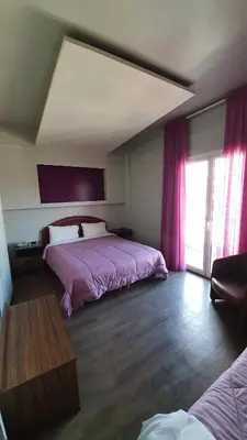 a bedroom with a large bed with purple sheets at Athens Lydia Hotel in Athens