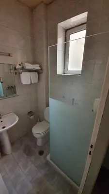 a bathroom with a shower and a toilet and a sink at Athens Lydia Hotel in Athens