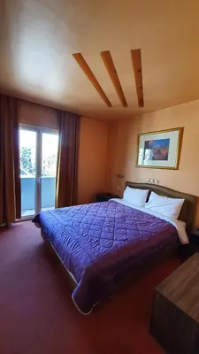 a bedroom with a bed with a purple comforter at Athens Lydia Hotel in Athens