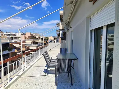 a balcony with a table and chairs on a building at Comfortable penthouse in Kallithea in Athens