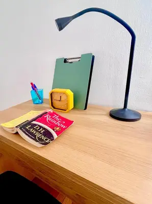 a desk with a lamp and a book on a table at Apartment in the center of Athens! in Athens
