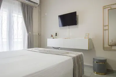 a bedroom with a bed and a tv on the wall at Urban Ceramic Apartment by GHH in Athens