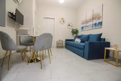 a living room with a blue couch and a table at Urban Ceramic Apartment by GHH in Athens