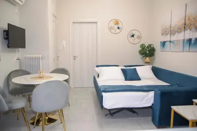 a bedroom with a blue bed and a table and chairs at Urban Ceramic Apartment by GHH in Athens