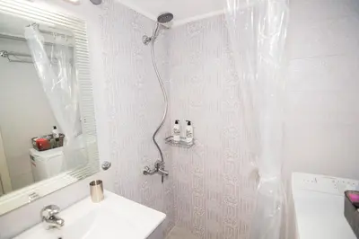 a bathroom with a shower curtain and a sink at Urban Ceramic Apartment by GHH in Athens