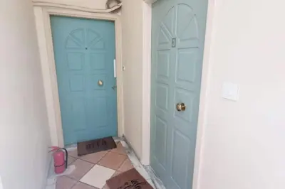 a hallway with two blue doors and a tile floor at Pavlina Artistic Βeauty 33sqm metro 7' in Athens