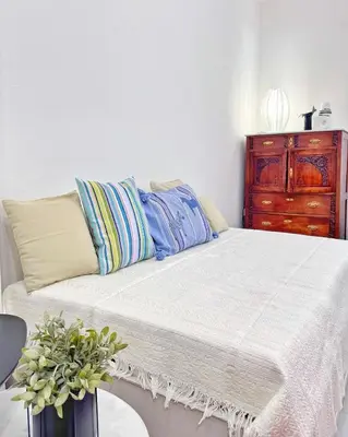 a bed with pillows and a dresser in a room at 26 HoMe in Athens