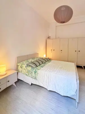 a bedroom with a white bed and a nightstand and a bed sidx sidx sidx at 26 HoMe in Athens