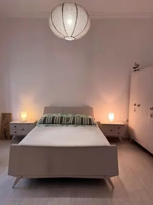 a bedroom with a large bed and a chandelier at 26 HoMe in Athens