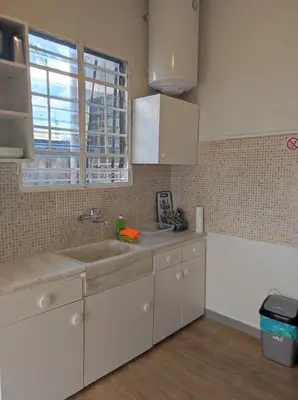 a kitchen with white cabinets and a sink at Onix 2 in Athens