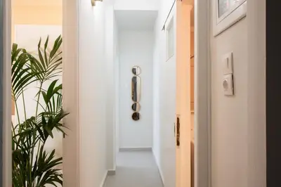 a hallway with a white door and a plant at Piraeus Home in Piraeus