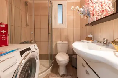 a bathroom with a washing machine and a sink at Piraeus Home in Piraeus