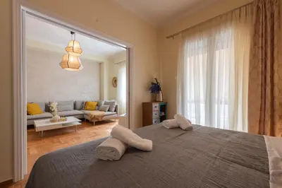 a bedroom with a bed and a living room at Piraeus Home in Piraeus