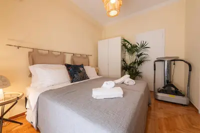 a bedroom with a bed with two towels on it at Piraeus Home in Piraeus