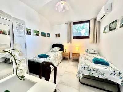 a room with two beds and a mirror at 2 bedroom self-contained apartment and swimming pool at Palm Tree Villa in Anavissos