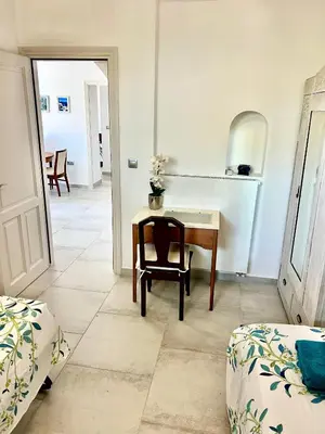 a room with a desk and a table and a chair at 2 bedroom self-contained apartment and swimming pool at Palm Tree Villa in Anavissos