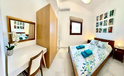 a small room with a bed and a desk at 2 bedroom self-contained apartment and swimming pool at Palm Tree Villa in Anavissos