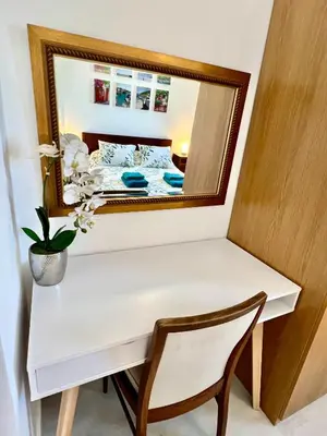 a dressing table with a mirror and a bed at 2 bedroom self-contained apartment and swimming pool at Palm Tree Villa in Anavissos