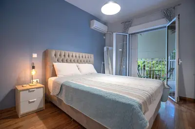 a bedroom with a large bed and a large window at Backyard Bliss in Ano Patisia by ΜΡS in Athens