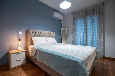 a bedroom with a large bed with blue walls at Backyard Bliss in Ano Patisia by ΜΡS in Athens