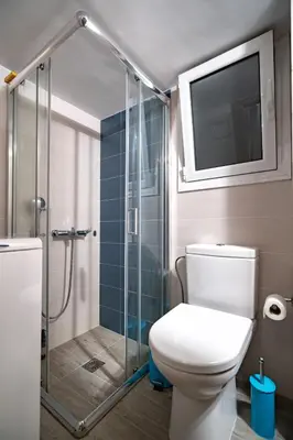 a bathroom with a toilet and a glass shower at Backyard Bliss in Ano Patisia by ΜΡS in Athens