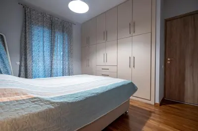 a bedroom with a bed and cabinets and a window at Backyard Bliss in Ano Patisia by ΜΡS in Athens