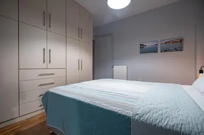 a bedroom with a large bed with white cabinets at Backyard Bliss in Ano Patisia by ΜΡS in Athens