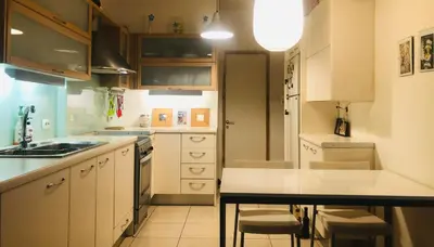 a kitchen with white cabinets and a counter top at Zenscapes in Athens