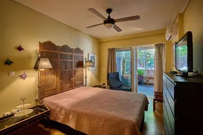 a bedroom with a bed and a ceiling fan at Cool ambiance, 2Brs , Private Garden & Parking in Athens