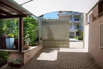 an outdoor shower with a glass door in a building at Cool ambiance, 2Brs , Private Garden & Parking in Athens