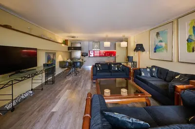 a living room with blue couches and a kitchen at Cool ambiance, 2Brs , Private Garden & Parking in Athens