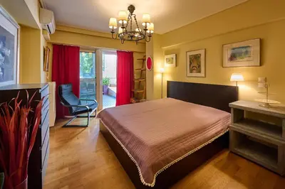a bedroom with a bed and a chair in it at Cool ambiance, 2Brs , Private Garden & Parking in Athens