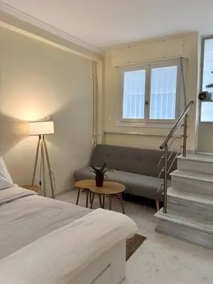 a bedroom with a bed and a couch and stairs at ZEUS - Zen Exarchia Urban Studio in Athens