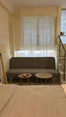 a living room with a couch and two tables at ZEUS - Zen Exarchia Urban Studio in Athens