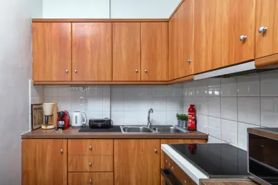 a kitchen with wooden cabinets and a sink at Jocasta - Cocoon Apartment Near Metro Station in Athens